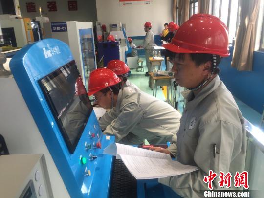 图为参赛手们在参加“切削加工智能制造单元安装与调试”和“切削加工智能制造单元生产与管控”的比赛。 宋秀杰 摄 图为参赛手们在参加“切削加工智能制造单元安装与调试”和“切削加工智能制造单元生产与管控”的比赛。 宋秀杰 摄